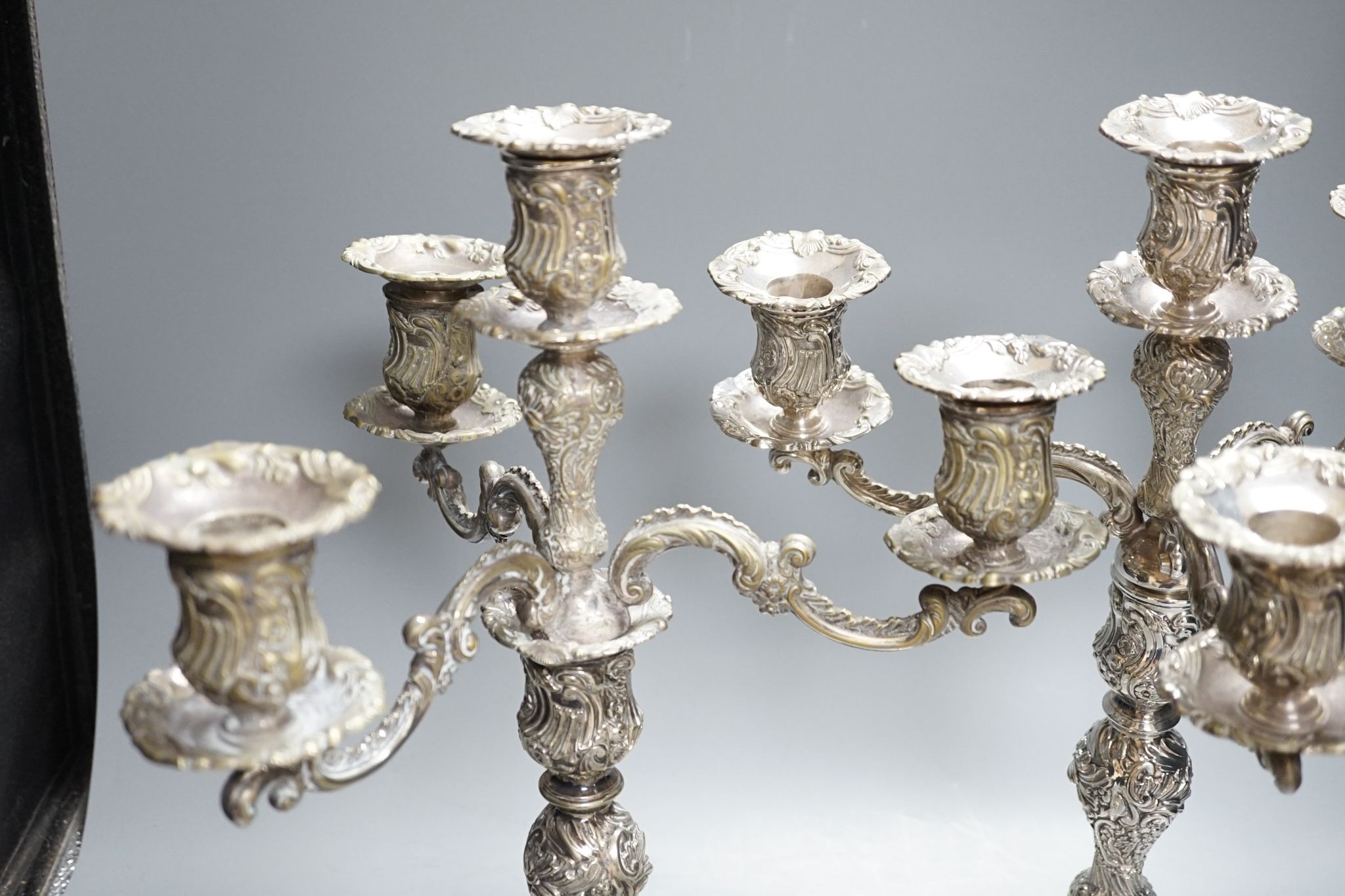 A pair of plated embossed three branch candelabra, 43cm